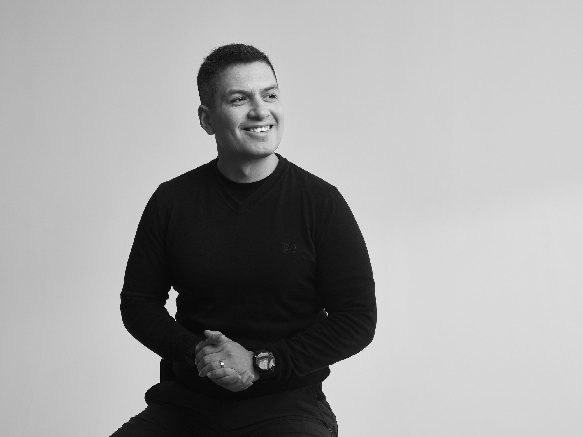 Daniel Laurean, seated and smiling, in a black sweater